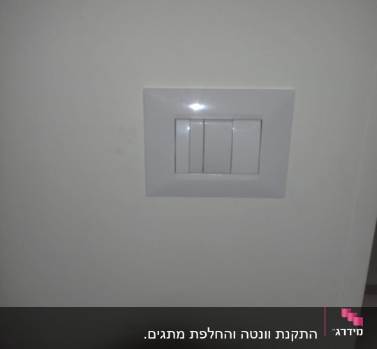 מתג חשמל לבן על קיר לבן